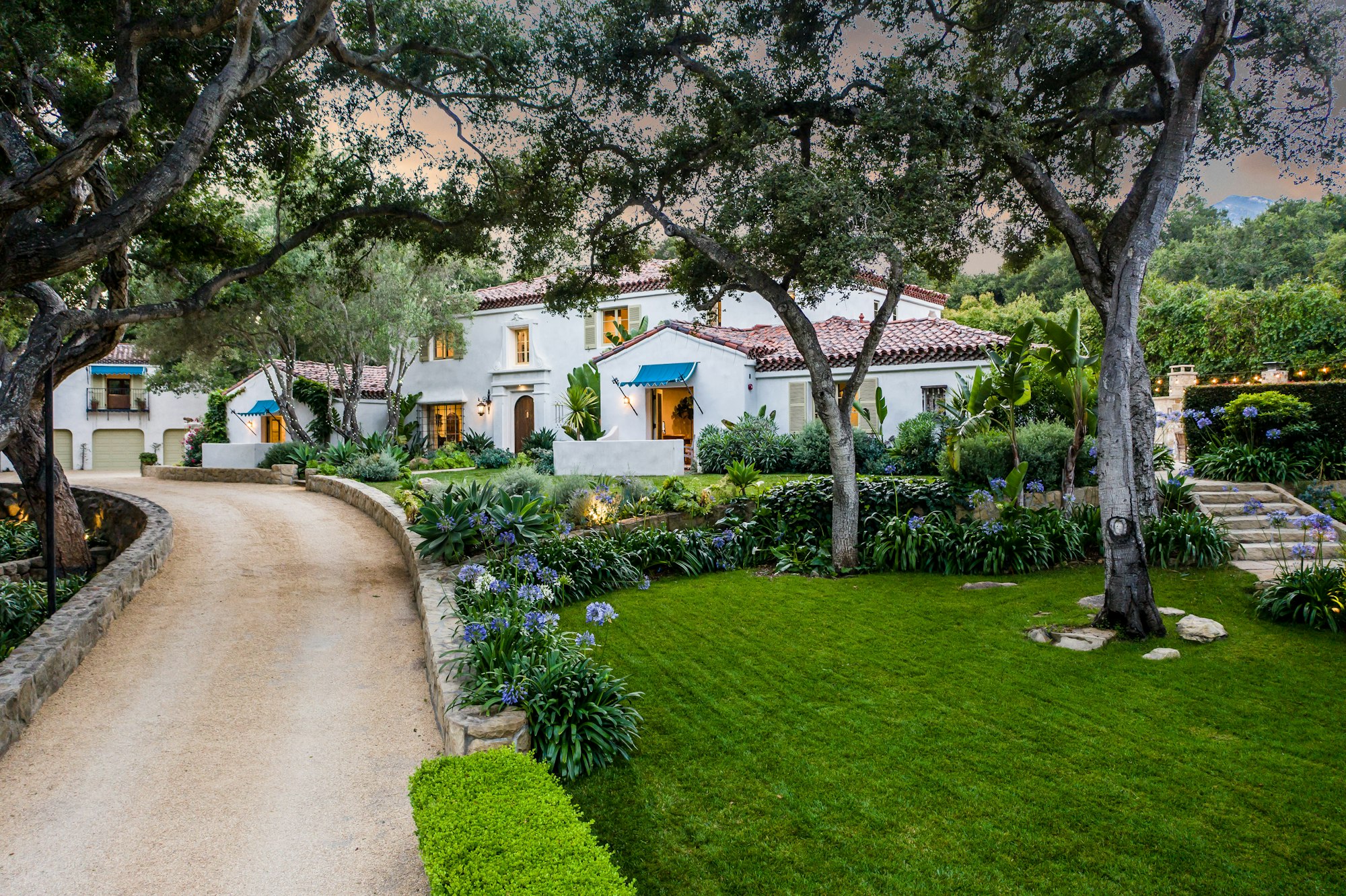 an empty driveway that leads to the front of this beautiful home