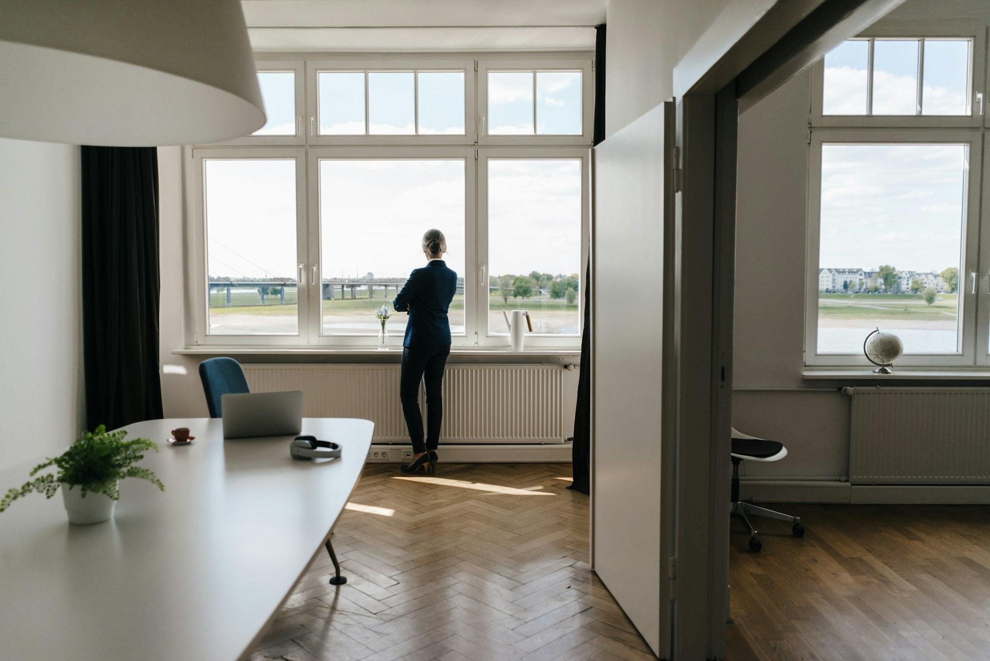 Businesswoman standing in modern office looking out of window