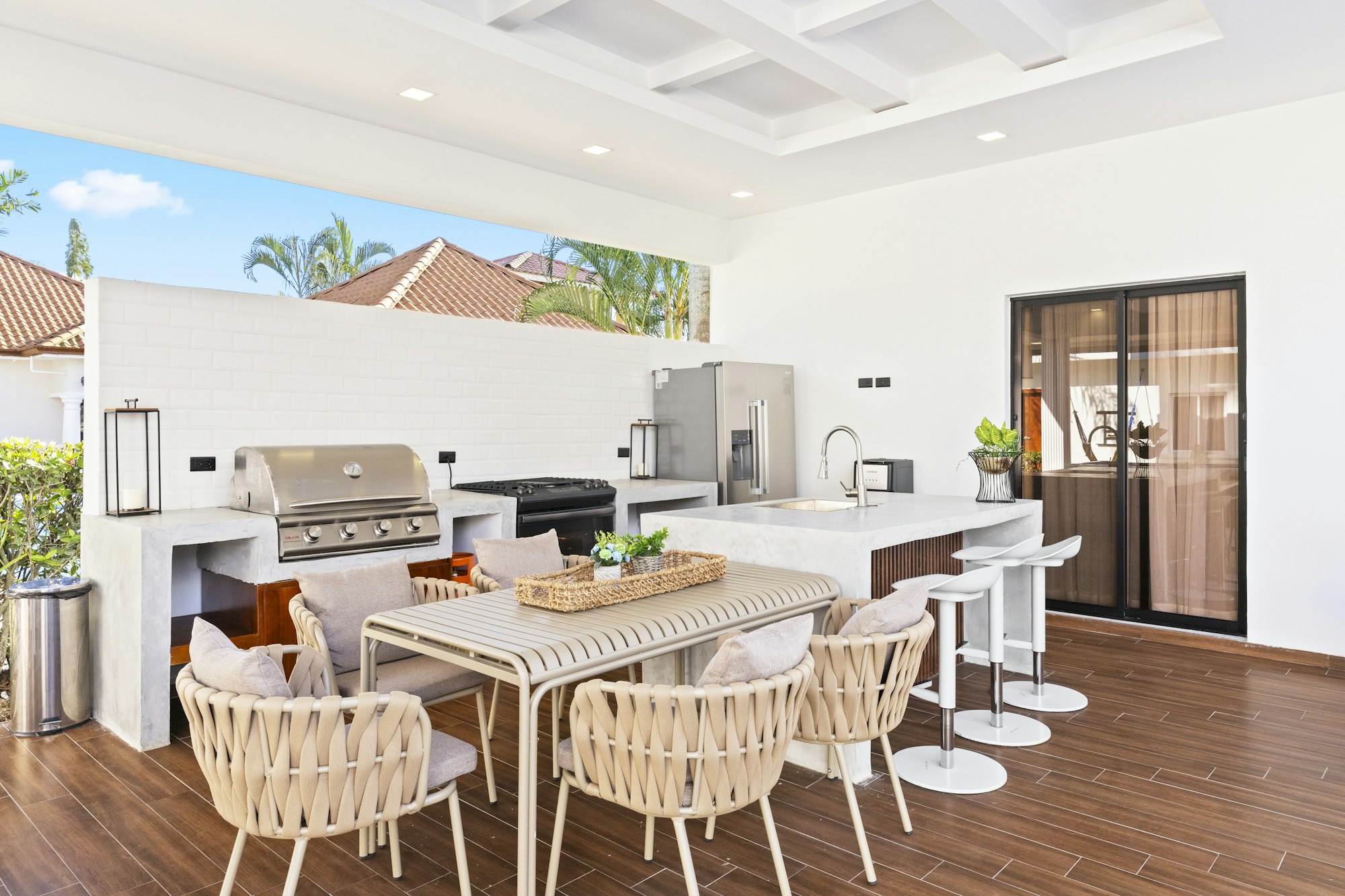 Patio with an outdoor kitchen, table, and chairs in a cozy room