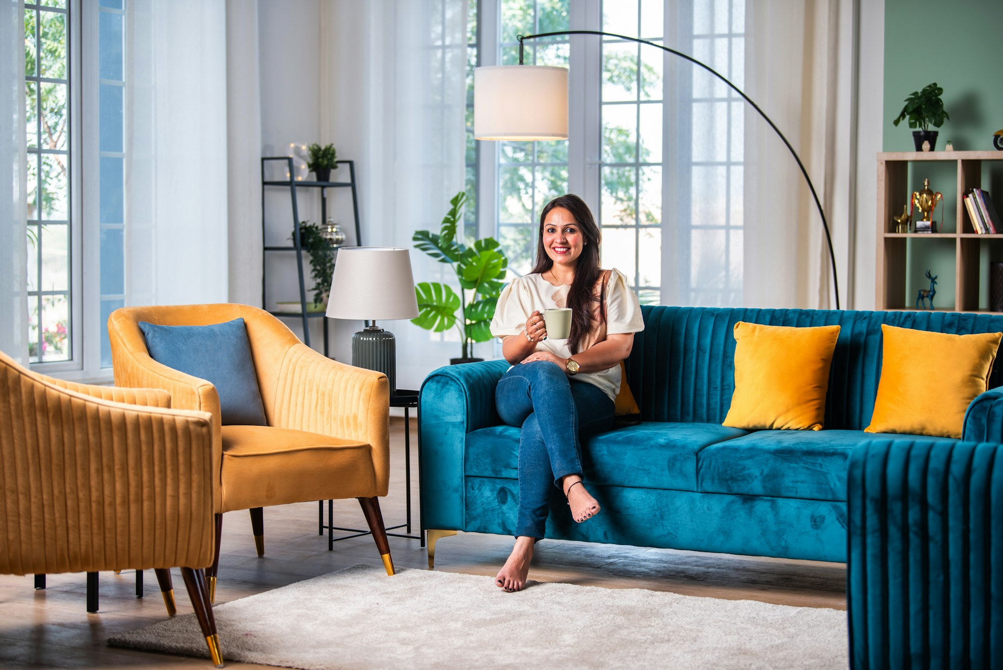 Pretty Indian woman on sofa in nice home, looking at camera.